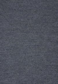 Grått stickat tyg med en fin, slät textur. Ytan har ett konsekvent, subtilt mönster över hela materialet.