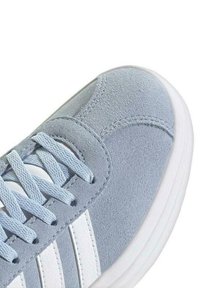 Sneaker in suede azzurro chiaro con dettagli in pelle bianca, caratterizzata da una superficie testurizzata, punta rotonda e lacci piatti. Design minimalista.