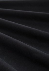 Tessuto nero esposto in pieghe, con una texture liscia e superficie uniforme, finitura opaca e senza modelli o embellishments visibili.
