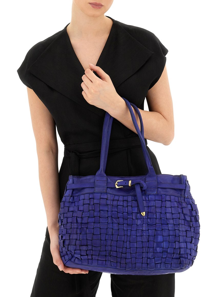 Borsa intrecciata in pelle blu reale con doppi manici, base piatta e dettagli in metallo dorato. La superficie testurizzata presenta un motivo a scacchiera.