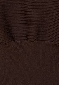 Tessuto di maglione a coste marrone con una finitura testurizzata, caratterizzato da linee orizzontali e una sezione leggermente arricciata in vita.