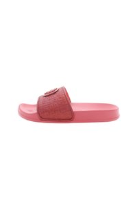 Różowa klapka z teksturowanym, wzorzystym paskiem, który posiada okrągłe logo. Podeszwa jest płaska i lekko wyprofilowana dla większego komfortu.