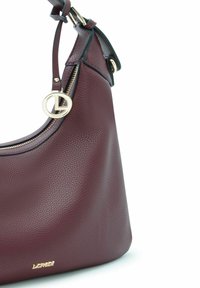 Sac à main en cuir bordeaux à la forme structurée, doté d'un détail en métal doré et d'une fermeture zippée, souligné par une bordure verte contrastante.