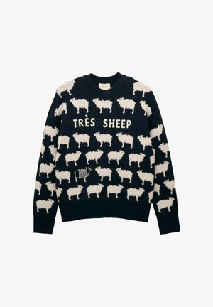 Námornícky sveter s bielym vzorom oviec, jednou pruhovanou ovcou a textom "TRÈS SHEEP" umiestneným na hrudi.
