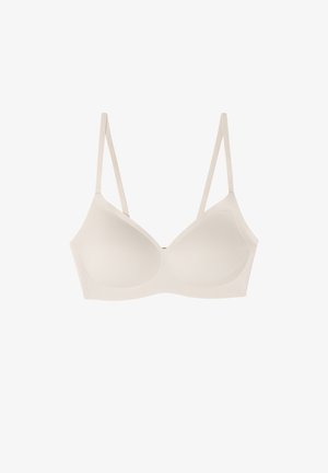 Lichtbeige draadloze beha met verstelbare bandjes, subtiele textuur en een gladde afwerking. Heeft een naadloos ontwerp en geen zichtbare hardware.