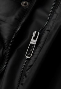 Giacca a vento nera con zip metallica elegante e linguetta testurizzata. Finitura liscia e opaca con cuciture visibili lungo i bordi.