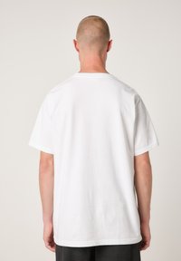 Weißes Baumwoll-T-Shirt, kurze Ärmel, Rundhalsausschnitt, lockere Passform, schlichtes Design, keine sichtbaren Logos oder Muster, Ansicht von hinten.