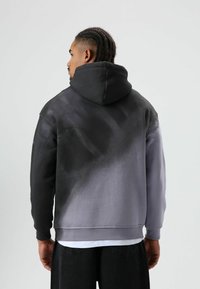 Hoodie met een verloopontwerp van zwart naar grijs, gemaakt van zachte stof. Geribbelde manchetten en zoom; losse pasvorm met een buidelzak.