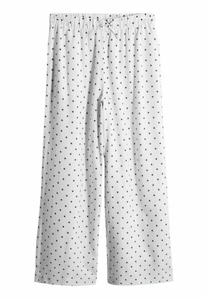 White pants with black polka dots and an elastic waistband, illustrating a relaxed, casual style.