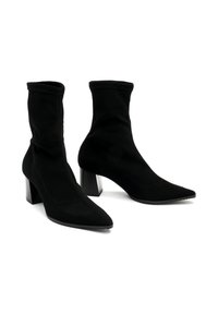 Czarne botki za kostkę wykonane z miękkiego zamszu, z szpiczastym noskiem, posiadające średniej wysokości blokowy obcas oraz elastyczny górny brzeg zapewniający dopasowanie.