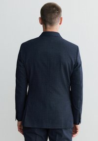 Giacca da completo in tessuto navy con una vestibilità su misura, caratterizzata da un sottile motivo a quadri, rever slim e dettagli con bottoni sui polsini.