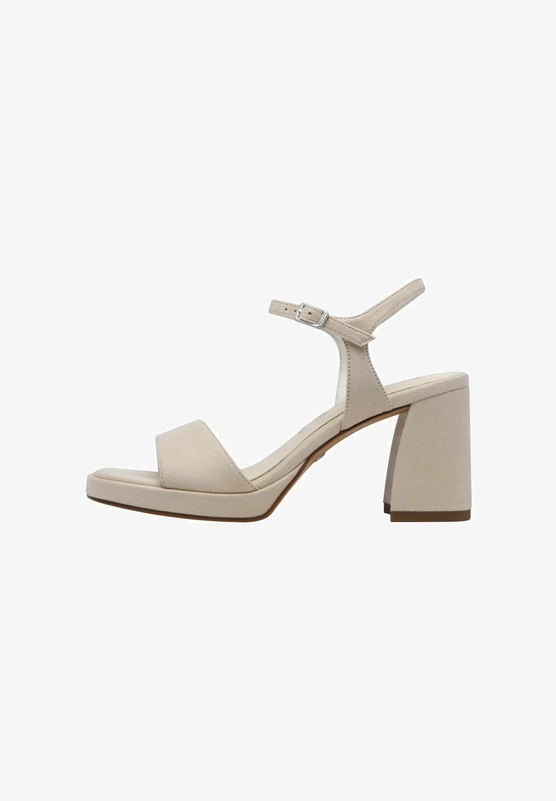 Sandales à talons en daim beige avec une large sangle sur les orteils, une sangle à la cheville avec boucle et un talon carré épais. Texture lisse, design minimal.