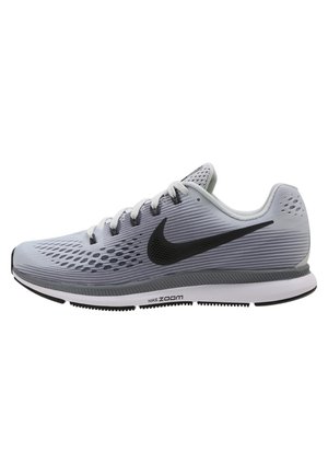 Zapatilla de running Nike Zoom de color gris claro con logo negro, parte superior de malla transpirable, suela blanca y detalles grises mostrada de lado.