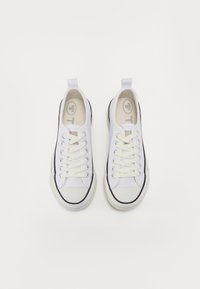 Sneakers bianchi in tela con accenti neri e suole in gomma. Presentano una punta tonda, design con lacci e un cordino sul tallone per una facile vestibilità.