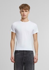 Hvit bomull t-skjorte med rund hals og korte ermer. Passformen er figurvennlig, med jevn tekstur og minimal design, uten mønster.