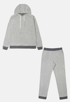 Grijs twee-delig loungewear-set bestaande uit een hoodie met witte trekkoorden en bijpassende tapse broeken met donkergrijze boorden. Gestructureerde stof.