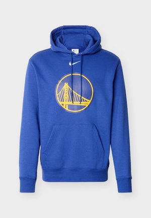 Kék kapucnis pulóver sárga Golden Gate híd logóval, amely egy körön belül helyezkedik el, felette fehér Nike pipa, elöl zsebbel és húzózsinóros kapucnival.