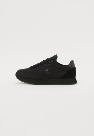 Black sneakers made of fabric and suede, featuring a smooth surface, round toe, black laces, and a subtle logo on the side.