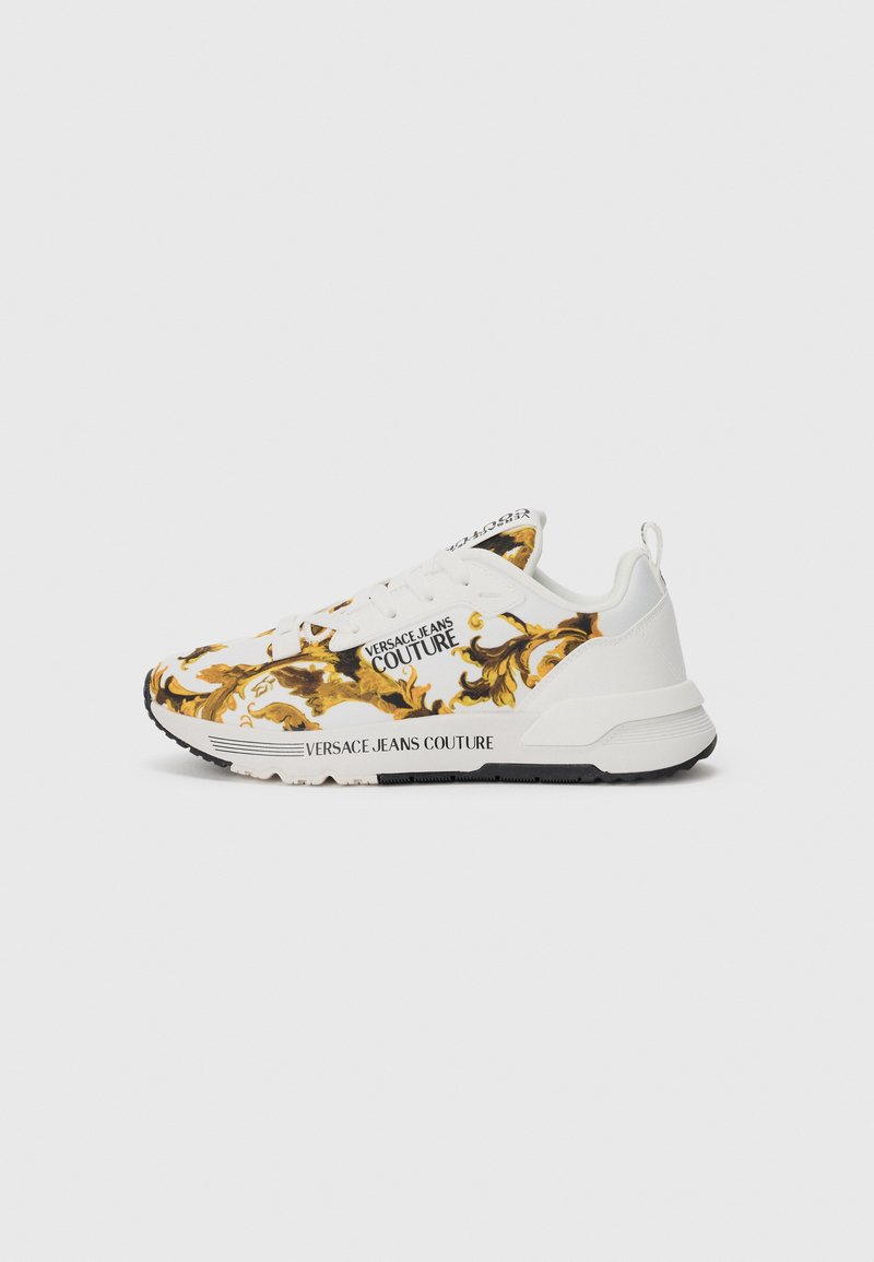 White sneakers featuring a vibrant gold and brown swirling pattern, along with black outsole and "VERSACE JEANS COUTURE" branding on the side.