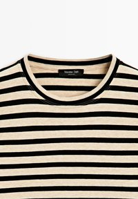 Beige-schwarzes T-Shirt mit horizontalen Streifen und Rundhalsausschnitt, mit sichtbarem Innenetikett mit der Aufschrift "Massimo Dutti Made in China".