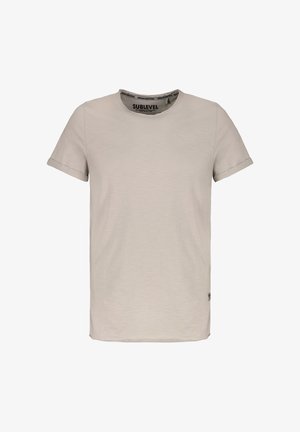 Plain beige short-sleeve crewneck T-shirt with rolled cuffs and a small logo tag near the bottom hem on a white background.