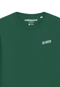 Groene langemouwen T-shirt van katoen; voorzien van een ronde hals, zachte textuur en witte tekst "GO GREEN!" op het linkerbovenborstgebied.