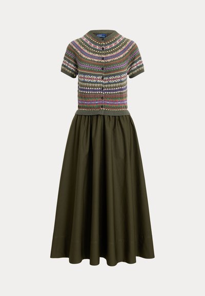 Cardigan à manches courtes boutonné avec des motifs géométriques multicolores, associé à une longue jupe unie couleur olive foncé.