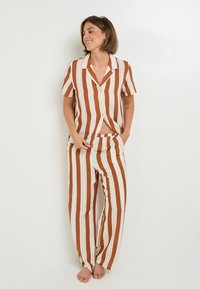 Set di pigiama a righe in marrone e crema, composto da una camicia a maniche corte con bottoni e pantaloni larghi con vita elastica.