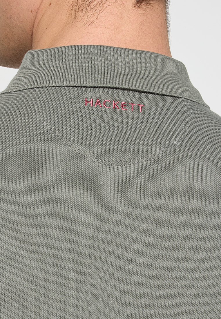 Gray polo shirt with textured fabric, featuring a narrow collar and small red "HACKETT" logo on the back of the neck.