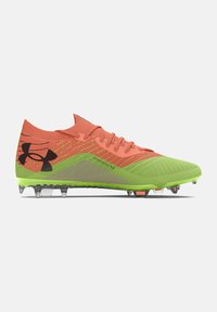 Zapato: tacos de fútbol en brillante color coral y verde con parte superior texturizada, logo negro prominente, clavos moldeados y diseño aerodinámico elegante.