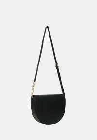 Borsa a tracolla nera a forma di mezzaluna con tracolla regolabile e dettaglio in catena dorata su sfondo neutro.