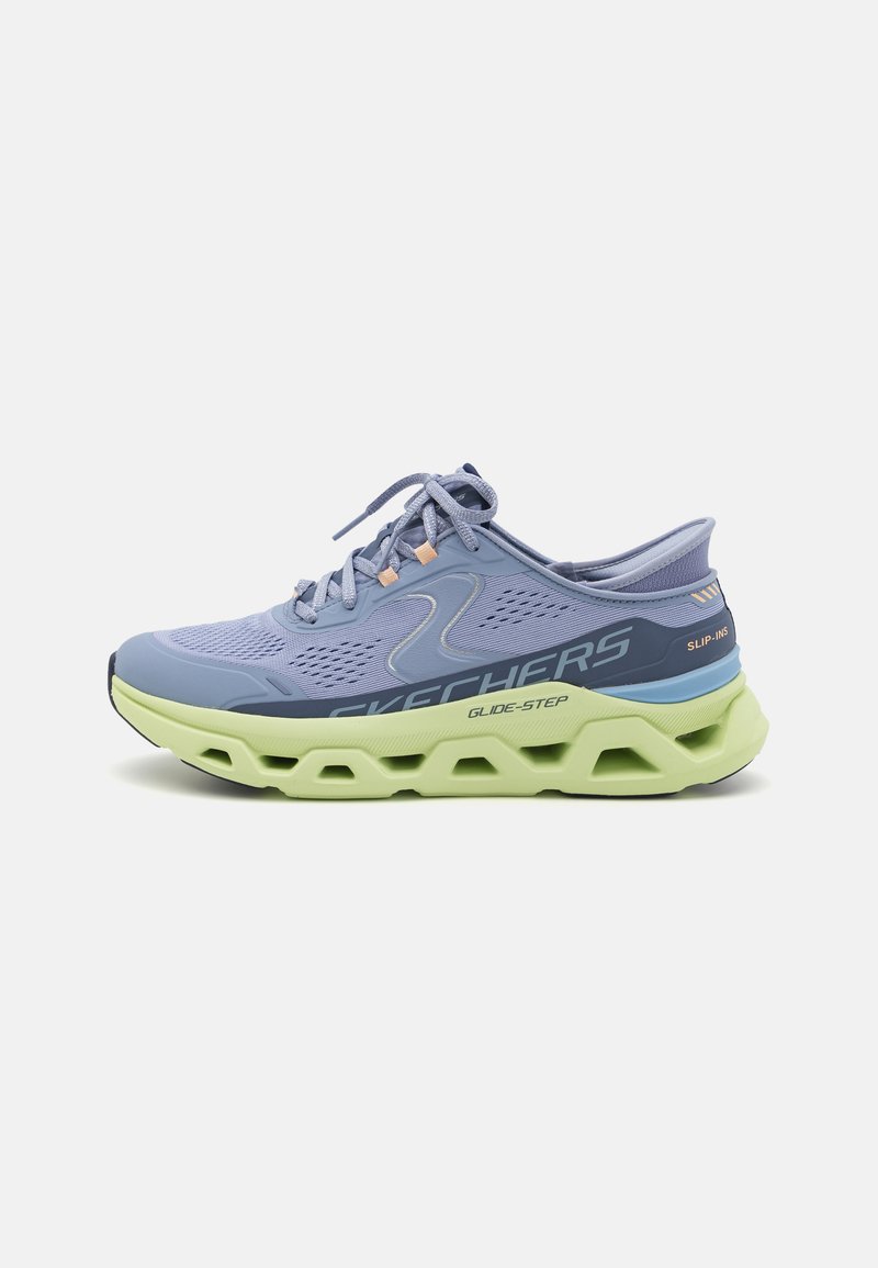 Chaussure de sport Skechers en bleu clair avec tige en mesh, semelle rembourrée verte, fermeture à lacets, bout rond et accents de logo.