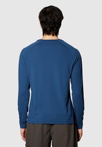 Niebieska, aktywna koszulka z długim rękawem, z teksturowanej tkaniny, z rękawami raglanowymi i płaskimi szwami. Posiada okrągły dekolt i dopasowany krój.