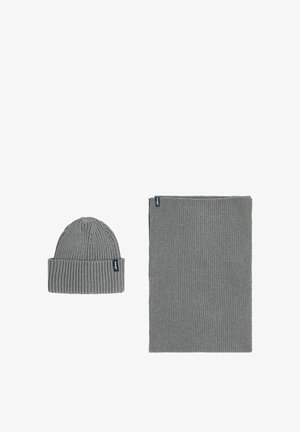 Grijze gebreide beanie met ribbeltextuur en bijpassende rechthoekige sjaal, voorzien van een klein, merklabel op elk item.