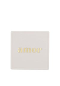 Kwadratowa, jasnoróżowa ceramiczna miska o gładkiej powierzchni. Na minimalistycznym tle znajduje się centralnie umieszczony złoty napis "amor".
