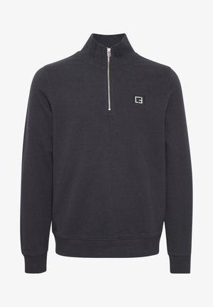 Crni dukserica sa četvrtim zatvaračem, napravljena od mekog materijala. Ima mali logotip na lijevoj strani te rebraste rukave i donji rub.