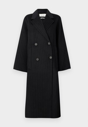 Manteau long noir à double boutonnage avec des rayures très discrètes, larges revers, deux poches avant et quatre boutons noirs.