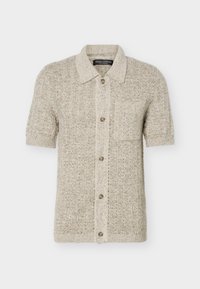 Cardigan beige a maniche corte in maglia con colletto, bottoni frontali e una tasca sul petto, realizzato con filato strutturato.