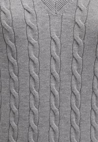 Grauer Strickpullover mit V-Ausschnitt, der ein strukturiertes Kabelmuster aufweist, das vertikal über den Stoff verläuft. Weiche und glatte Textur.