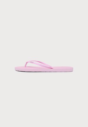 Enkele lichtroze teenslipper met dunne bandjes, zijaanzicht op een effen lichte achtergrond.