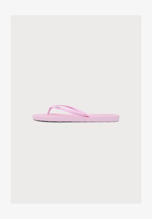 Una sandalia flip-flop de color rosa claro con tiras finas, mostrada de lado sobre un fondo claro y liso.