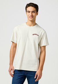 Hvid bomulds t-shirt med rund halsudskæring og korte ærmer. "WRANGLER" logo i bordeaux broderi på venstre bryst.