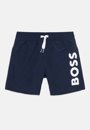 Granatowe kąpielówki z białym sznurkiem i dużym białym logo „BOSS” na prawej nodze.