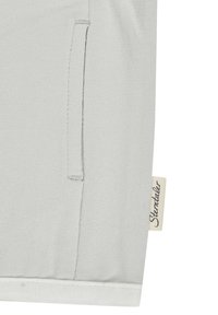 Light gray fabric top with a side pocket and a small tag that reads "Stentaller." The material is smooth with a subtle texture.