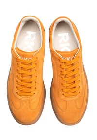 Pomarańczowe zamszowe sneakersy o teksturowanej powierzchni, okrągłym nosku i cienkiej gumowej podeszwie. Posiadają sześć oczek na sznurówki i płaskie sznurówki. Logo widoczne wewnątrz.