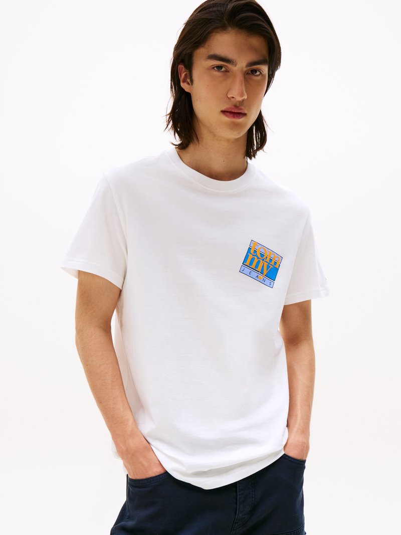 Witte katoenen t-shirt met een ronde hals en korte mouwen, voorzien van een kleurrijk grafisch logo op de linkerborst.
