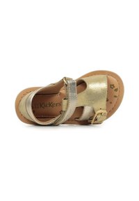 Sandalia de cuero dorado con punta abierta, correa ajustable en el tobillo y plantilla marrón con patrones florales. Detalles de hebilla en la correa.