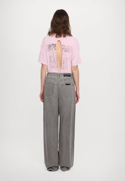 Pink short-sleeve shirt with a back cutout, paired with high-waisted, wide-leg gray jeans featuring back pockets and subtle texture.