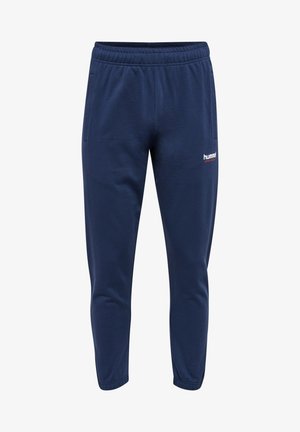 Marineblauwe katoenen sweatpants met een taillekoord, taps toelopende benen, zijzakken en een wit logo op de linkeronderzijde van het been.
