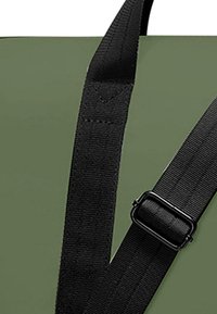 Geantă de culoare verde măslinie cu curele negre din webbing. Prezintă un design texturat și o cataramă din plastic pentru ajustare. Material extrem de durabil.